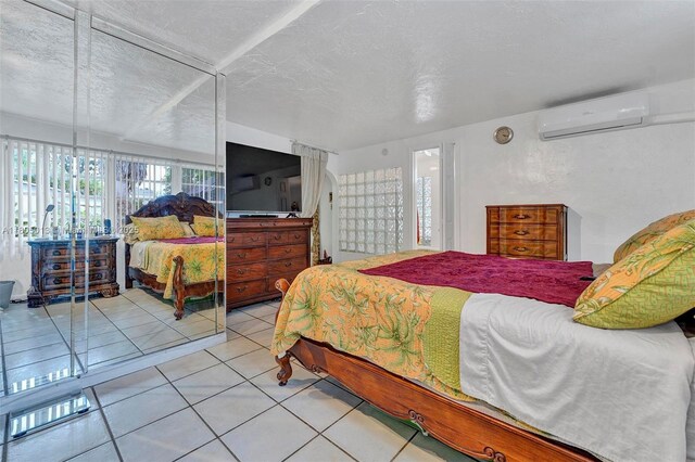 2442 Fillmore St, Hollywood, FL 33020 - bedroom with a wall mounted air conditioner, a textured ceiling, and tile patterned floors