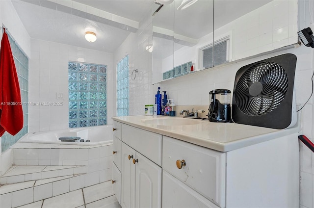 2442 Fillmore St, Hollywood, FL 33020 - bathroom featuring tiled bath, vanity, tile patterned floors, and tile walls