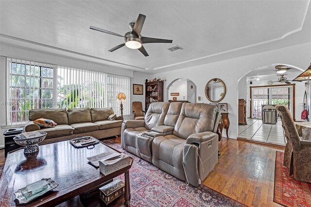 2442 Fillmore St, Hollywood, FL 33020 - living area with arched walkways, a ceiling fan, hardwood / wood-style floors, and a tray ceiling