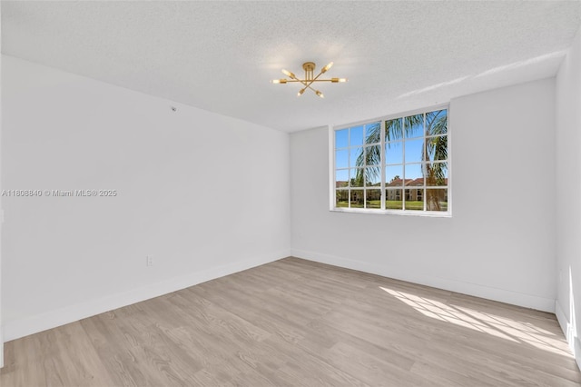 2173 Renaissance Blvd Unit 204, Miramar, FL 33025 - spare room with a chandelier, wood finished floors, and a textured ceiling