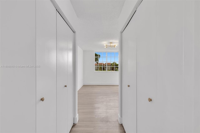 2173 Renaissance Blvd Unit 204, Miramar, FL 33025 - hallway featuring light wood finished floors and a chandelier