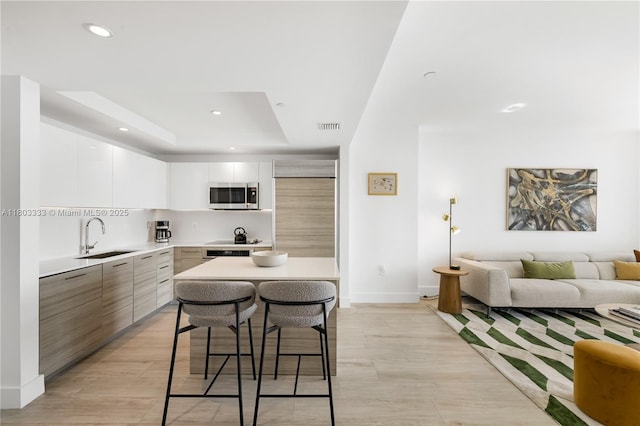 121 NE 34th St Unit 2412, Miami, FL 33137 - kitchen featuring appliances with stainless steel finishes, a sink, modern cabinets, light countertops, and recessed lighting