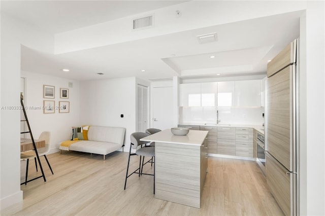 121 NE 34th St Unit 2412, Miami, FL 33137 - kitchen with modern cabinets, a breakfast bar area, a sink, built in fridge, and stainless steel oven