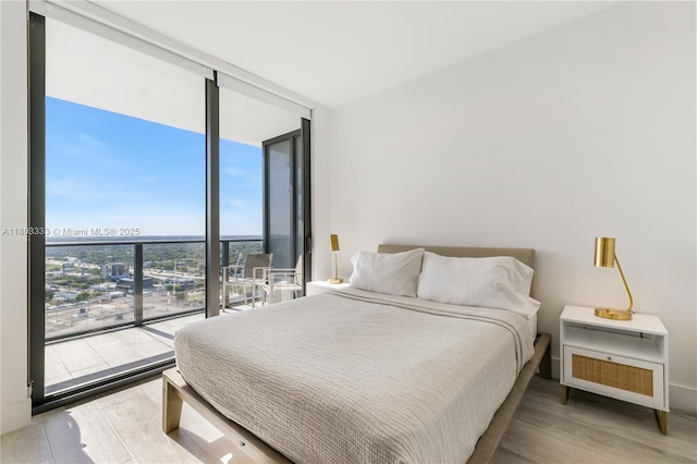 121 NE 34th St Unit 2412, Miami, FL 33137 - bedroom featuring a wall of windows, wood finished floors, and baseboards