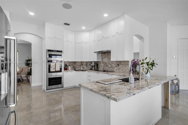 3560 SW 145th Ave, Miramar, FL 33027 - kitchen featuring a sink, arched walkways, light stone countertops, backsplash, and white cabinets