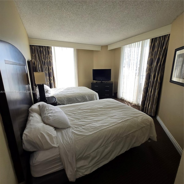 17375 Collins Ave Unit 1101, Sunny Isles Beach, FL 33160 - bedroom with a textured ceiling, carpet flooring, and baseboards