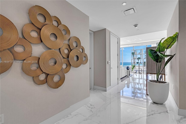 15701 Collins Ave Unit 705, Sunny Isles Beach, FL 33160 - corridor with marble tiled floors, baseboards, floor to ceiling windows, and a water view