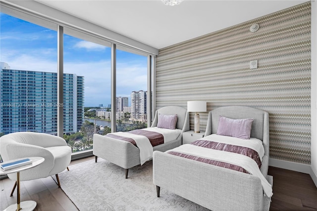 15701 Collins Ave Unit 705, Sunny Isles Beach, FL 33160 - bedroom featuring hardwood / wood-style floors, wallpapered walls, a city view, baseboards, and a wall of windows