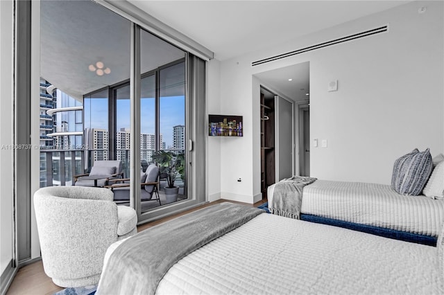 15701 Collins Ave Unit 705, Sunny Isles Beach, FL 33160 - bedroom with wood finished floors, expansive windows, access to exterior, baseboards, and a city view