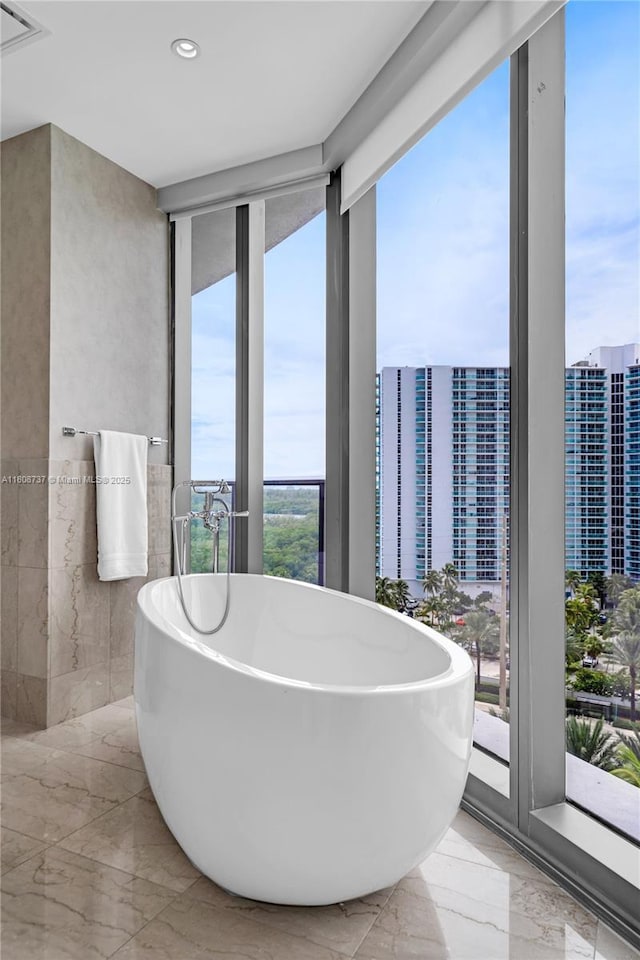 15701 Collins Ave Unit 705, Sunny Isles Beach, FL 33160 - bathroom featuring marble tiled floors, a freestanding tub, and recessed lighting