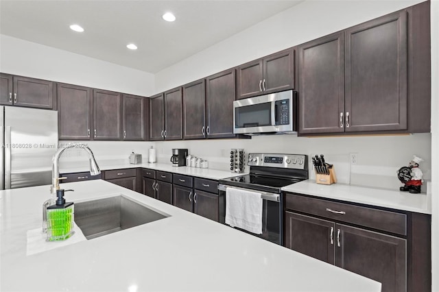 16450 Sea Turtle Pl, Loxahatchee, FL 33470 - kitchen with appliances with stainless steel finishes, a sink, light countertops, dark brown cabinetry, and recessed lighting