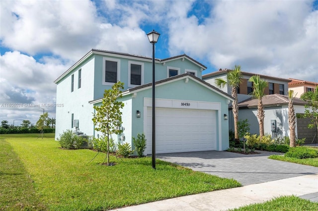 16450 Sea Turtle Pl, Loxahatchee, FL 33470 - view of front facade featuring stucco siding, a front lawn, driveway, and an attached garage