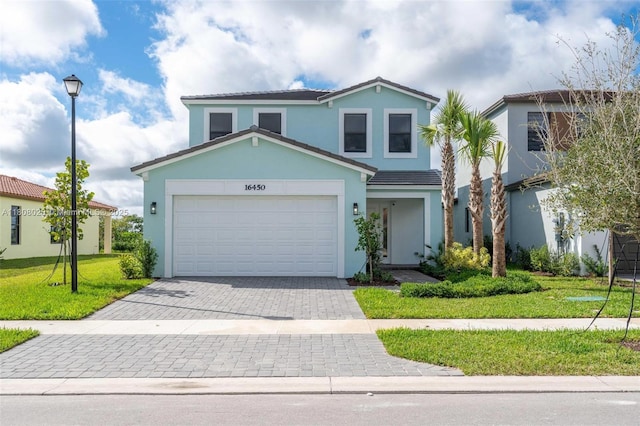 16450 Sea Turtle Pl, Loxahatchee, FL 33470 - traditional-style house with decorative driveway, stucco siding, a front lawn, an attached garage, and a tiled roof