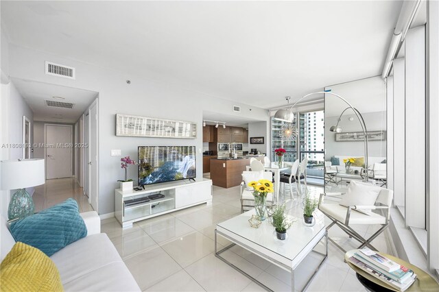 485 Brickell Ave Unit 1604, Miami, FL 33131 - living room featuring a water view, tile patterned flooring, a view of city, and baseboards