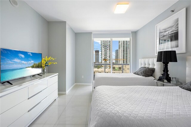 485 Brickell Ave Unit 1604, Miami, FL 33131 - bedroom with a city view, baseboards, and light tile patterned floors