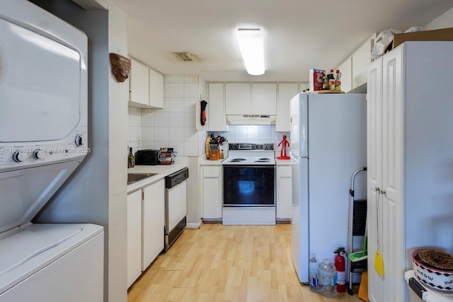 6870 SW 45th Ln Unit 8, Miami, FL 33155 - kitchen with white appliances, stacked washer / dryer, light countertops, light wood-style flooring, and backsplash