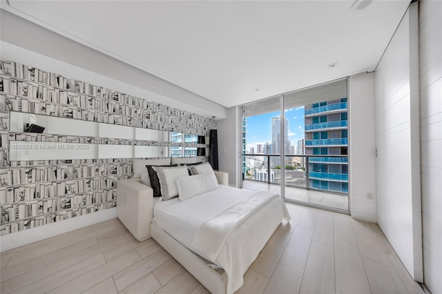 55 SE 6th St Unit 2803, Miami, FL 33131 - bedroom with floor to ceiling windows, a view of city, access to exterior, and wood finished floors