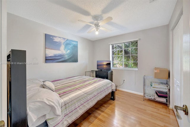 21519 SW 90th Ave, Cutler Bay, FL 33189 - bedroom featuring light wood-type flooring, a textured ceiling, baseboards, and ceiling fan