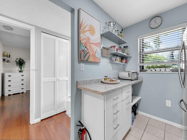 367 S Federal Hwy Unit B206, Deerfield Beach, FL 33441 - kitchen featuring baseboards, white cabinets, open shelves, and light stone counters