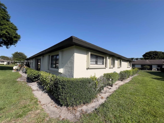 10198 Dovewood Ln Unit A, Boynton Beach, FL 33436 - view of home's exterior featuring stucco siding and a yard