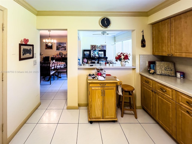 10198 Dovewood Ln Unit A, Boynton Beach, FL 33436 - kitchen featuring brown cabinets, light tile patterned floors, a chandelier, a ceiling fan, and crown molding