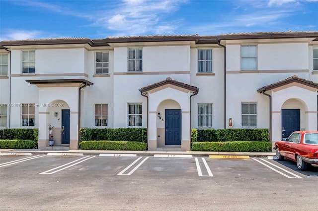 8199 W 36th Ave Unit 5, Hialeah, FL 33018 - view of property featuring uncovered parking, stucco siding, and a tile roof