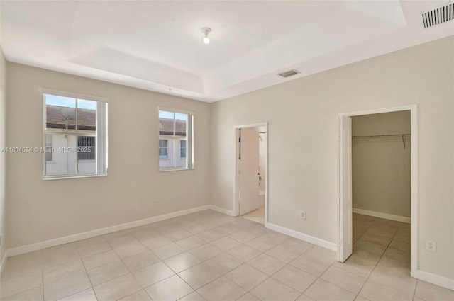 8199 W 36th Ave Unit 5, Hialeah, FL 33018 - unfurnished bedroom with a raised ceiling, a walk in closet, light tile patterned flooring, and a closet