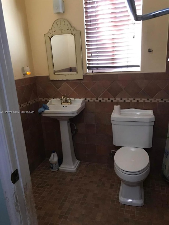 444 SW 26th Rd, Miami, FL 33129 - half bathroom featuring toilet, tile walls, wainscoting, and tile patterned flooring