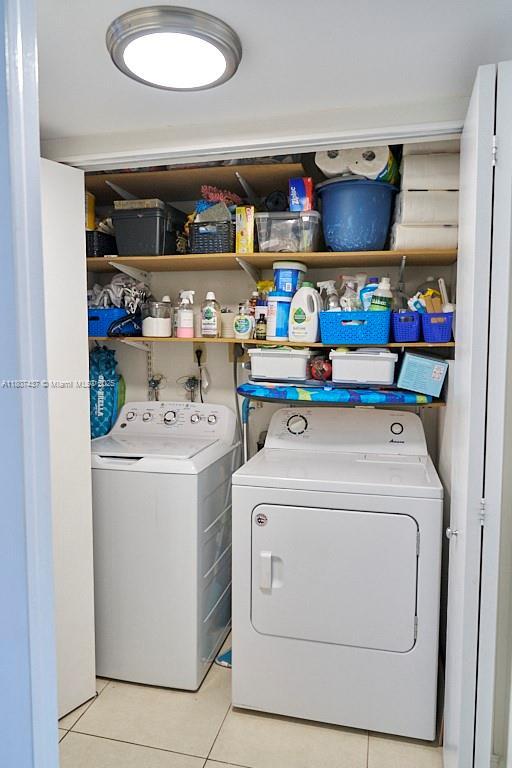 20105 NE 3rd Ct Unit 9, Miami, FL 33179 - laundry room with washer and clothes dryer and light tile patterned floors
