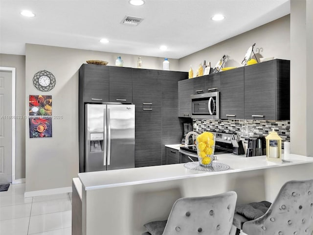 3502 NW 13th St, Lauderhill, FL 33311 - kitchen with appliances with stainless steel finishes, a breakfast bar, a peninsula, light countertops, and recessed lighting
