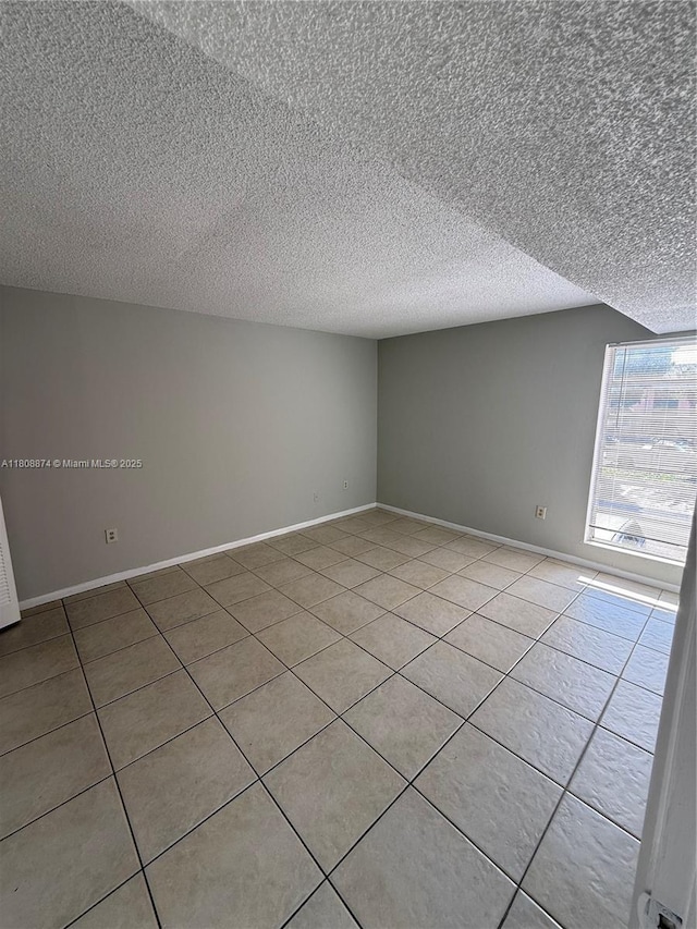 4705 NW 7th St Unit 203-7, Miami, FL 33126 - spare room featuring light tile patterned floors, a textured ceiling, and baseboards