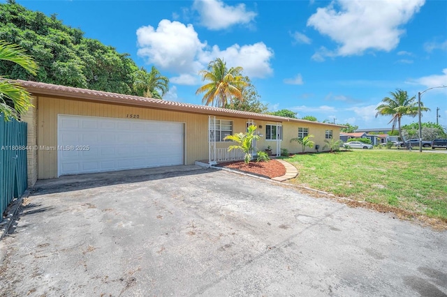 1520 N 25th Ave, Hollywood, FL 33020 - ranch-style house featuring an attached garage, asphalt driveway, a front lawn, and a tile roof
