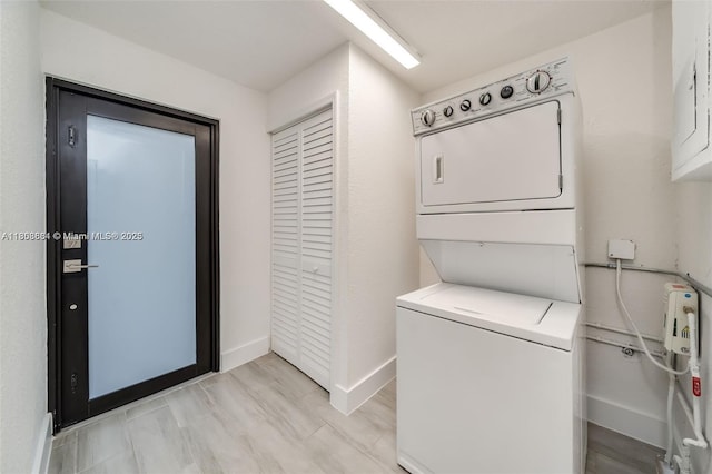 2447 Fletcher St, Hollywood, FL 33020 - washroom featuring estacked washer and dryer, baseboards, and electric panel