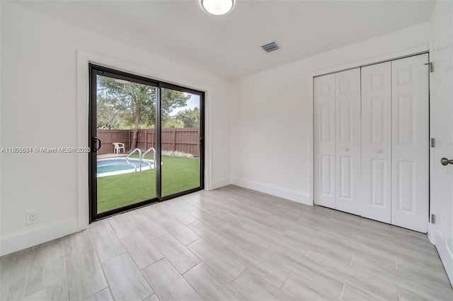 2447 Fletcher St, Hollywood, FL 33020 - unfurnished bedroom featuring access to outside, baseboards, a closet, and light wood-style floors