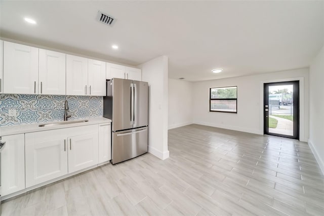 2447 Fletcher St, Hollywood, FL 33020 - kitchen with freestanding refrigerator, a sink, light countertops, backsplash, and white cabinetry