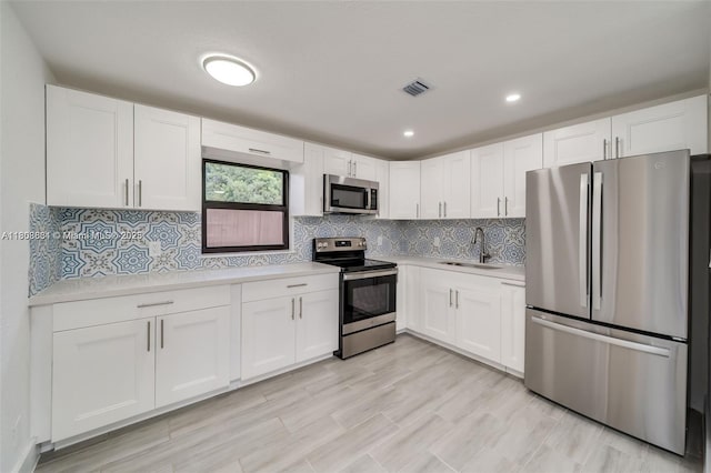 2447 Fletcher St, Hollywood, FL 33020 - kitchen featuring stainless steel appliances, a sink, light countertops, white cabinets, and recessed lighting