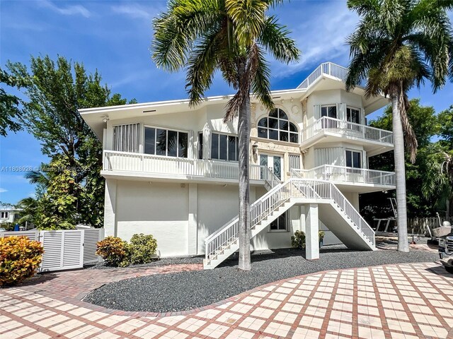 168 Indian Mound Trl, Tavernier, FL 33070 - rear view of house featuring stucco siding, a balcony, french doors, and stairway