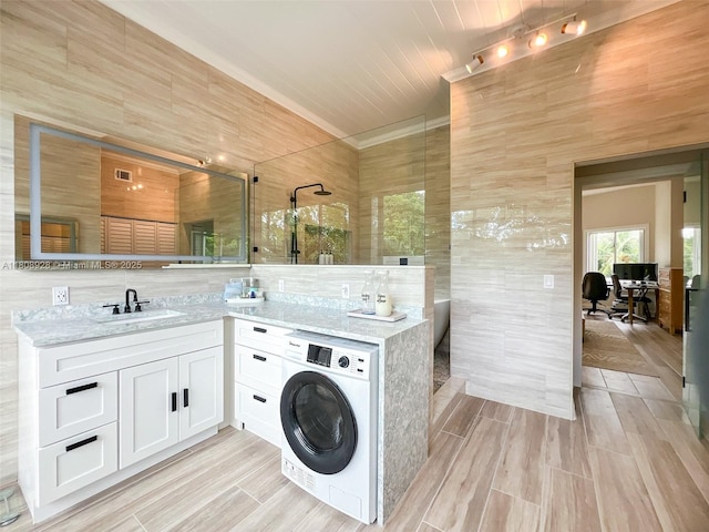 168 Indian Mound Trl, Tavernier, FL 33070 - full bath featuring washer / clothes dryer, vanity, walk in shower, tile walls, and wood finished floors