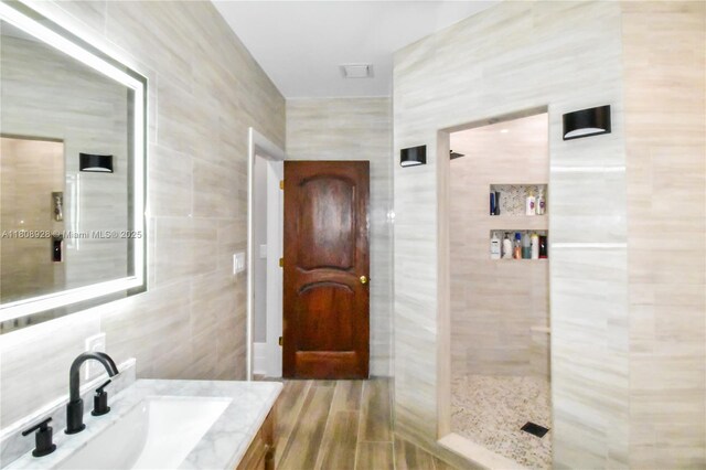 168 Indian Mound Trl, Tavernier, FL 33070 - bathroom featuring tile walls, vanity, tiled shower, and wood finished floors