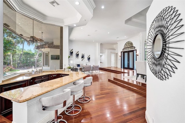 169 Dockside Cir, Weston, FL 33327 - kitchen with light stone counters, recessed lighting, wood-type flooring, dark brown cabinetry, and open floor plan