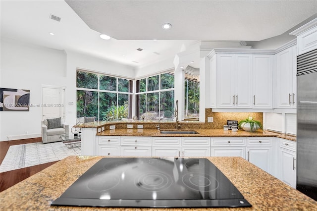 169 Dockside Cir, Weston, FL 33327 - kitchen with a sink, black cooktop, stainless steel built in refrigerator, white cabinets, and recessed lighting