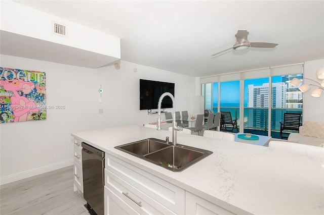 1830 S Ocean Dr Unit 1605, Hallandale Beach, FL 33009 - kitchen featuring dishwasher, a sink, light stone counters, white cabinetry, and light wood-style flooring