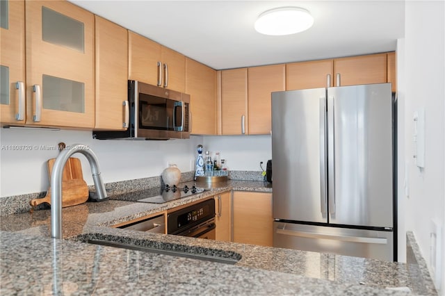 2101 Brickell Ave Unit 1702, Miami, FL 33129 - kitchen with black appliances, glass insert cabinets, light stone counters, and a sink
