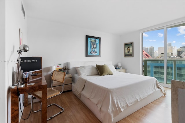 2101 Brickell Ave Unit 1702, Miami, FL 33129 - bedroom with access to exterior, wood finished floors, a wall of windows, and a view of city