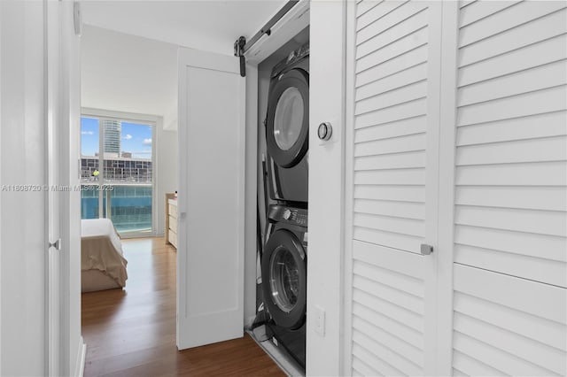 2101 Brickell Ave Unit 1702, Miami, FL 33129 - laundry area featuring stacked washing machine and dryer, dark wood-style floors, and a barn door