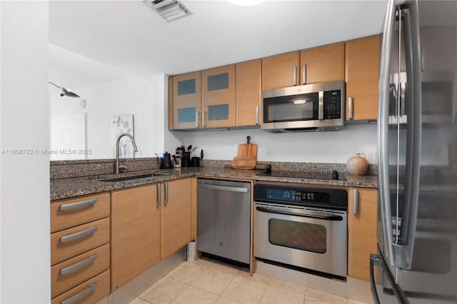 2101 Brickell Ave Unit 1702, Miami, FL 33129 - kitchen featuring stainless steel appliances, a sink, dark stone counters, and glass insert cabinets
