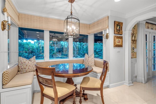 7360 SW 164th St, Palmetto Bay, FL 33157 - dining room with breakfast area, light tile patterned floors, arched walkways, ornamental molding, and a chandelier