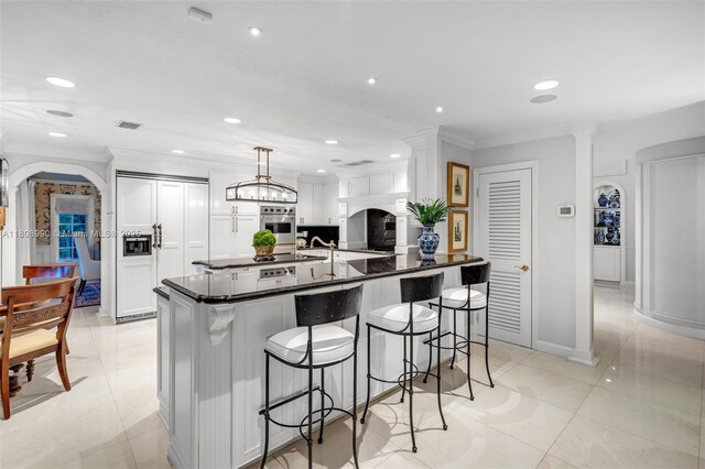 7360 SW 164th St, Palmetto Bay, FL 33157 - kitchen with crown molding, white cabinetry, a kitchen breakfast bar, recessed lighting, and paneled fridge