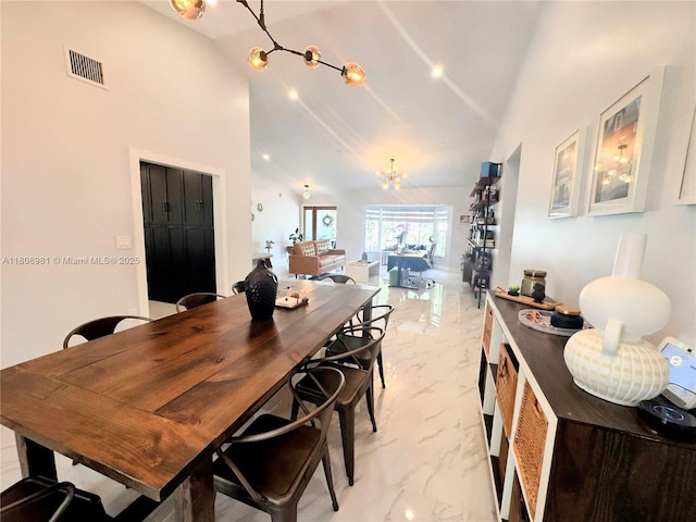 14870 SW 152nd Ct, Miami, FL 33196 - dining space featuring a chandelier, light marble finish floors, and high vaulted ceiling