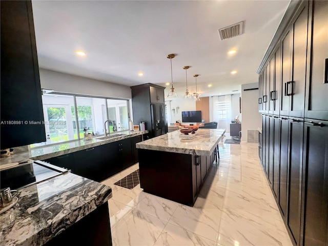 14870 SW 152nd Ct, Miami, FL 33196 - kitchen with black fridge with ice dispenser, a center island, recessed lighting, light stone countertops, and a sink